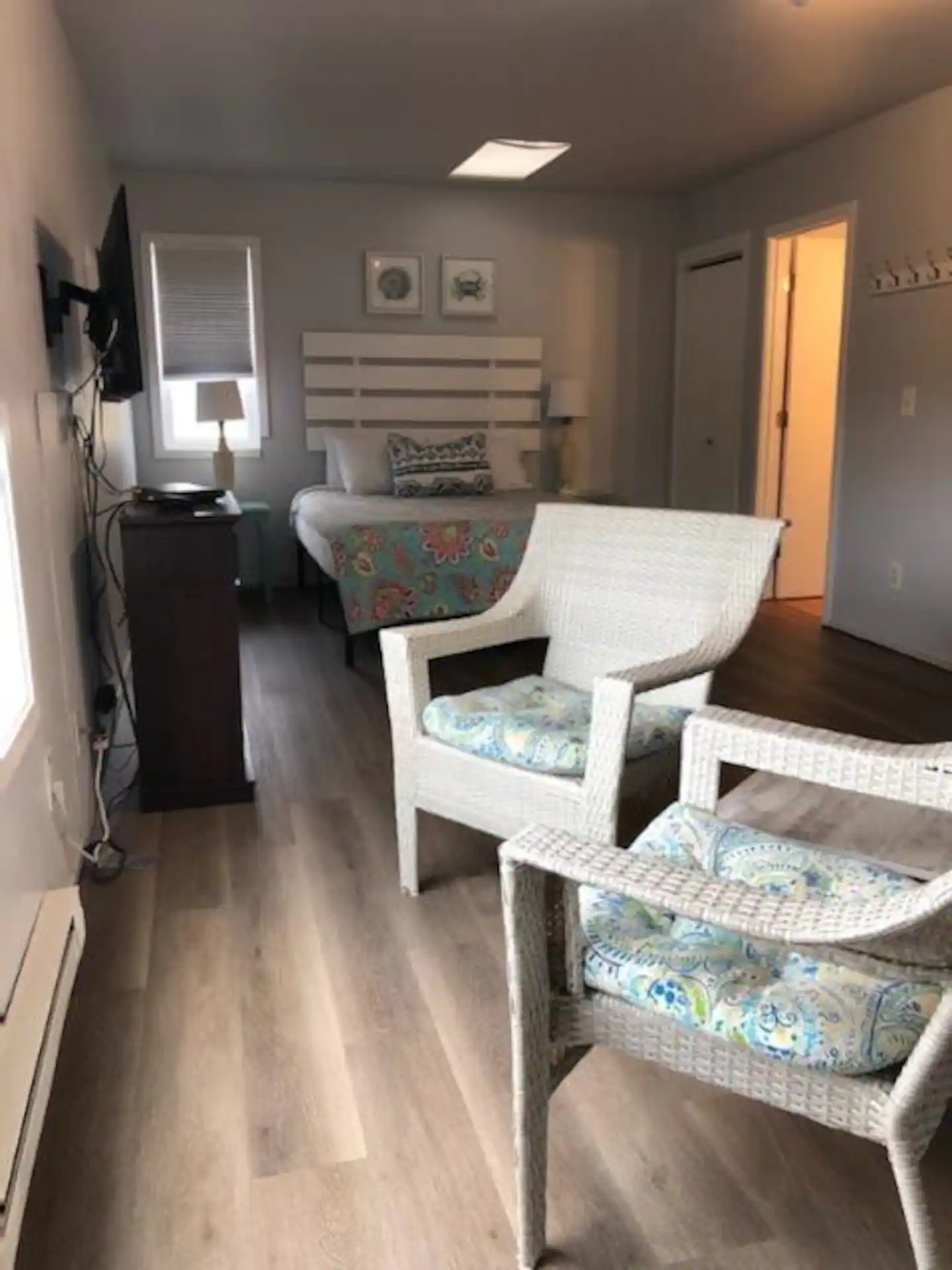 Inside view from the entrance of The Lighthouse showing the TV with seating and the queen bed