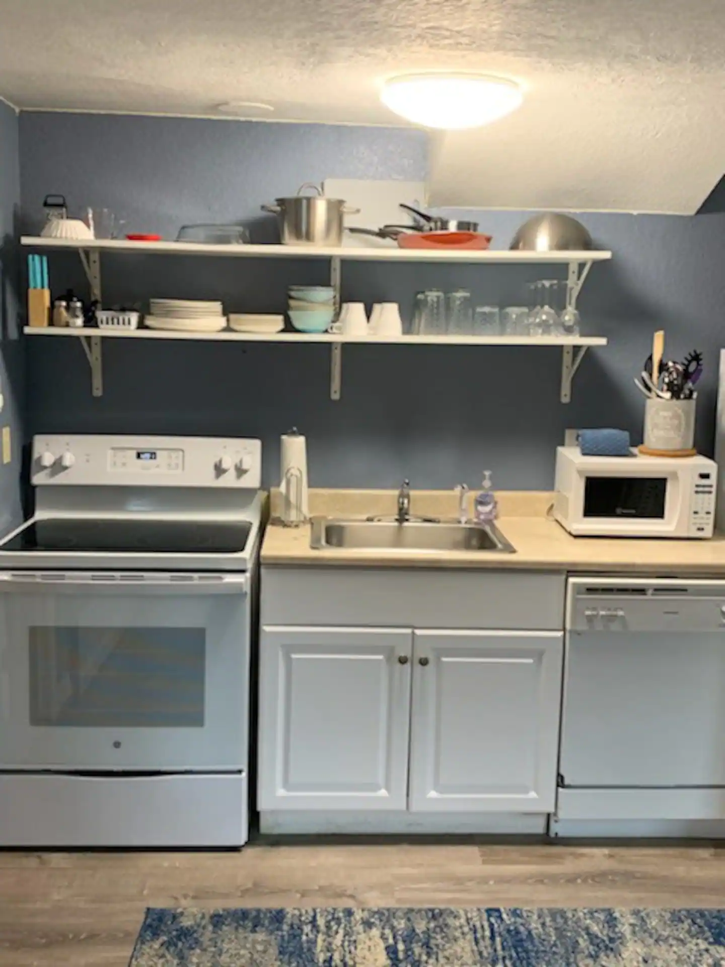 The Cottage's kitchen with oven, dishwasher, microwave and dishes